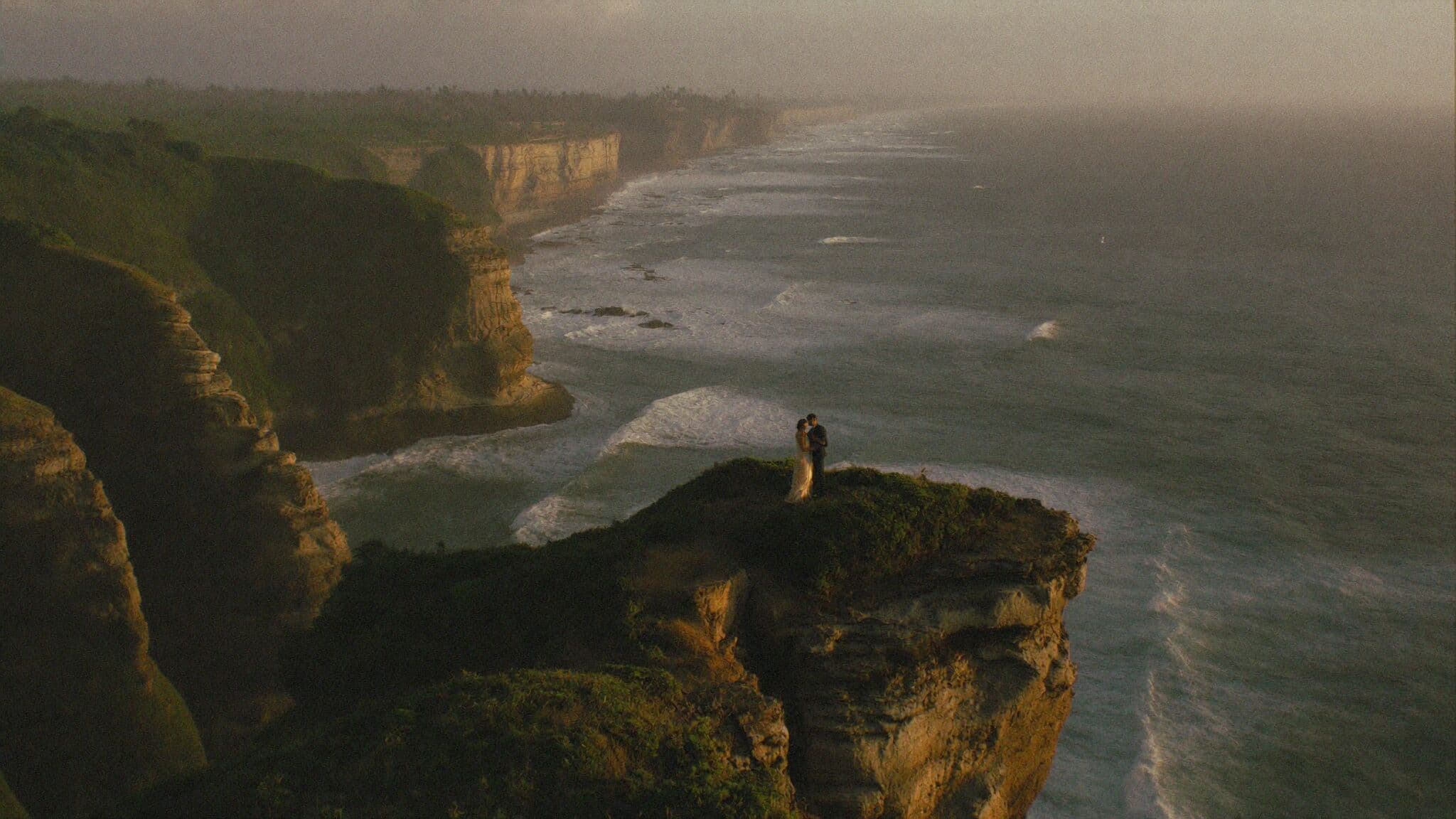 Couple on the Uluwatu cliffs above the Indian Ocean at sunset during their Bali elopement