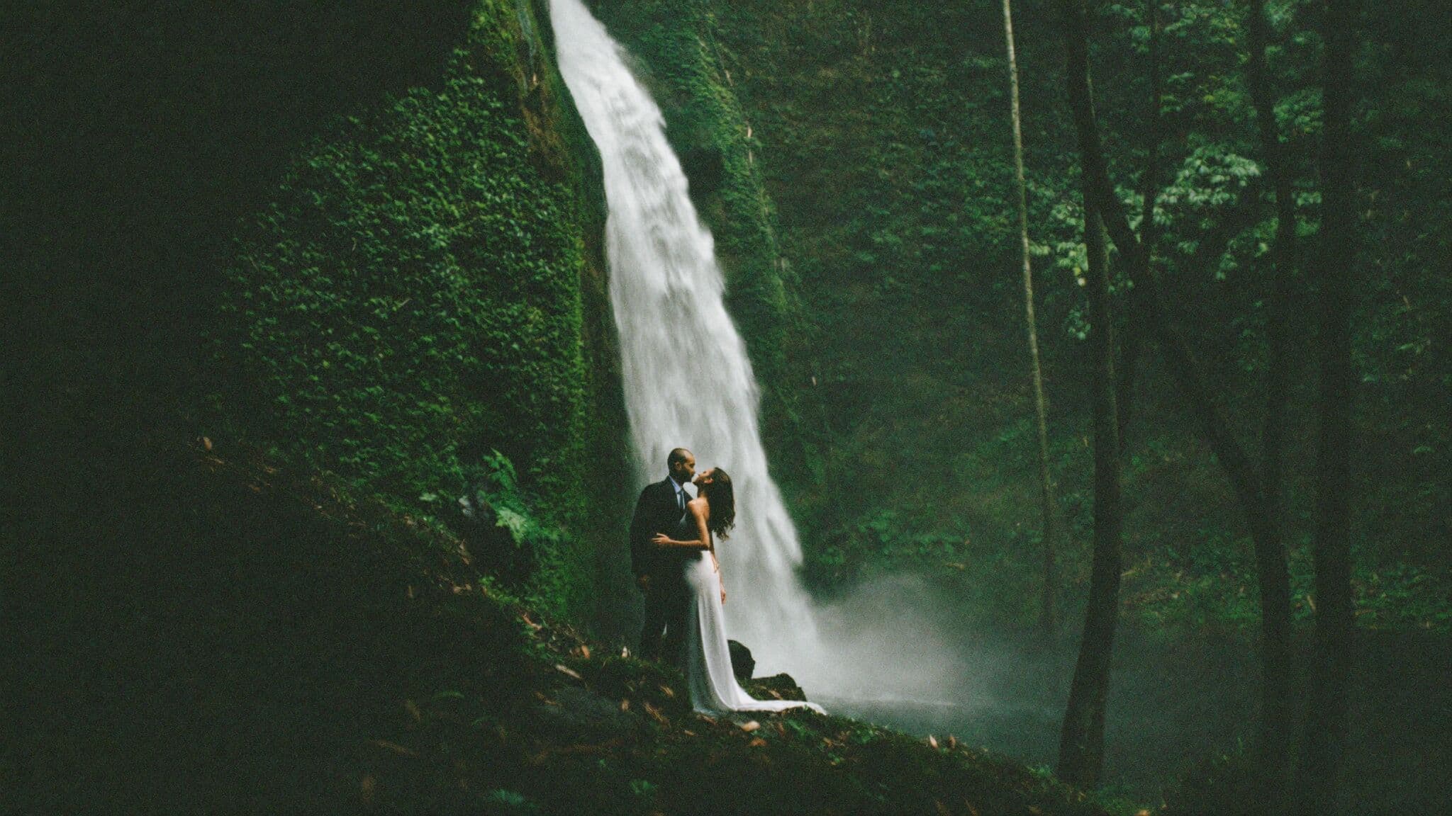 Couple beneath Banyumala waterfall in the Munduk highlands during their Bali elopement