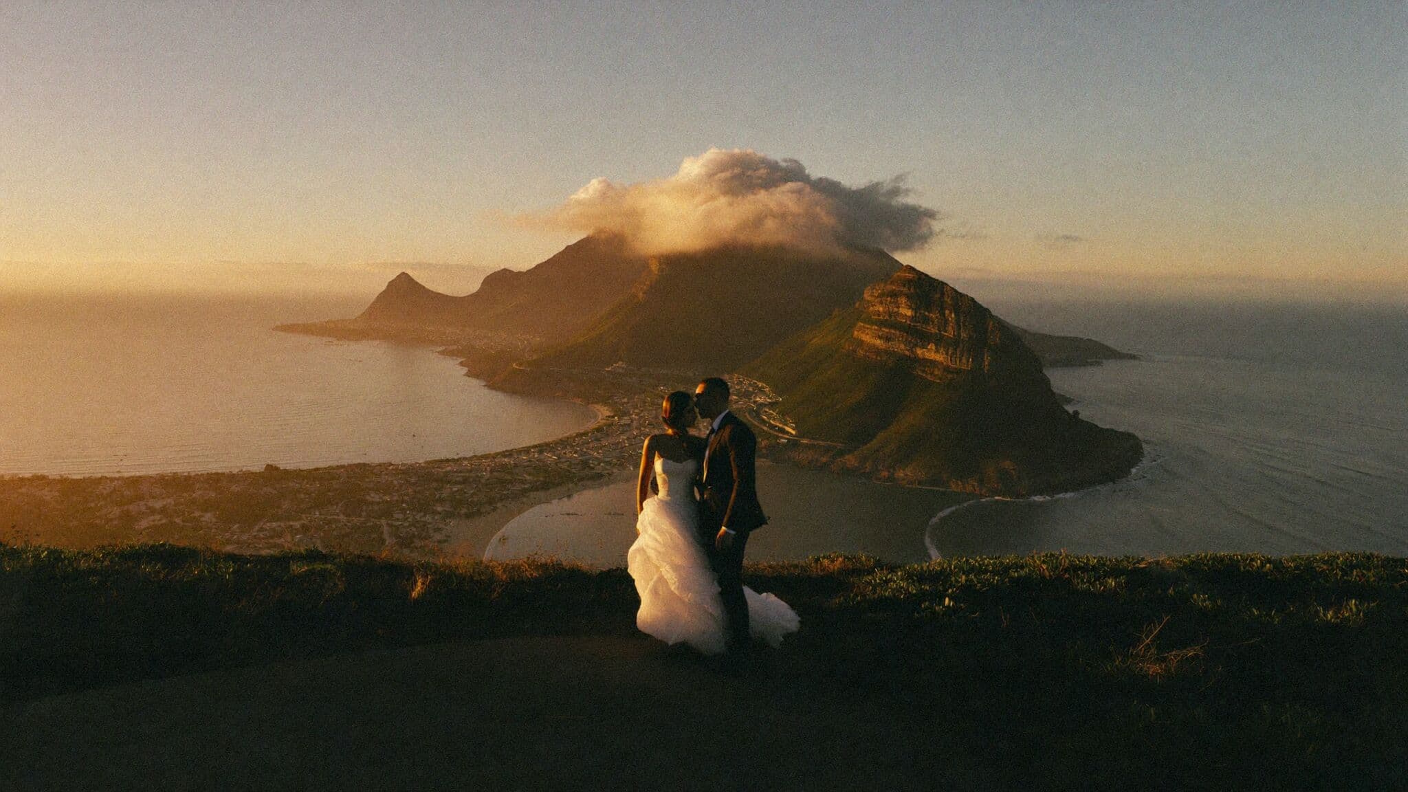 Couple on a ridge above the city with Table Mountain behind them during their Cape Town elopement