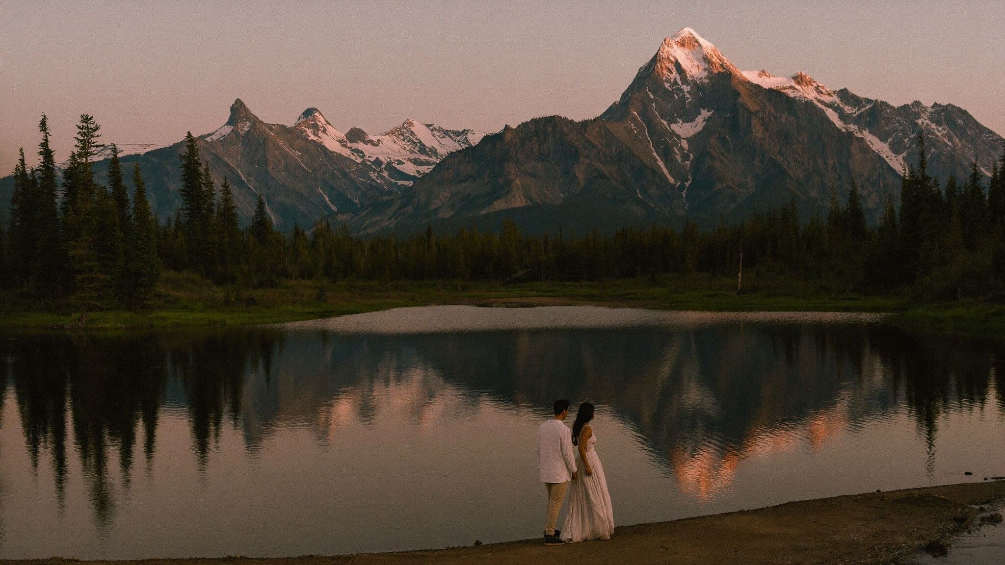 Couple exchanging vows beside a turquoise alpine lake at sunrise during their Colorado elopement