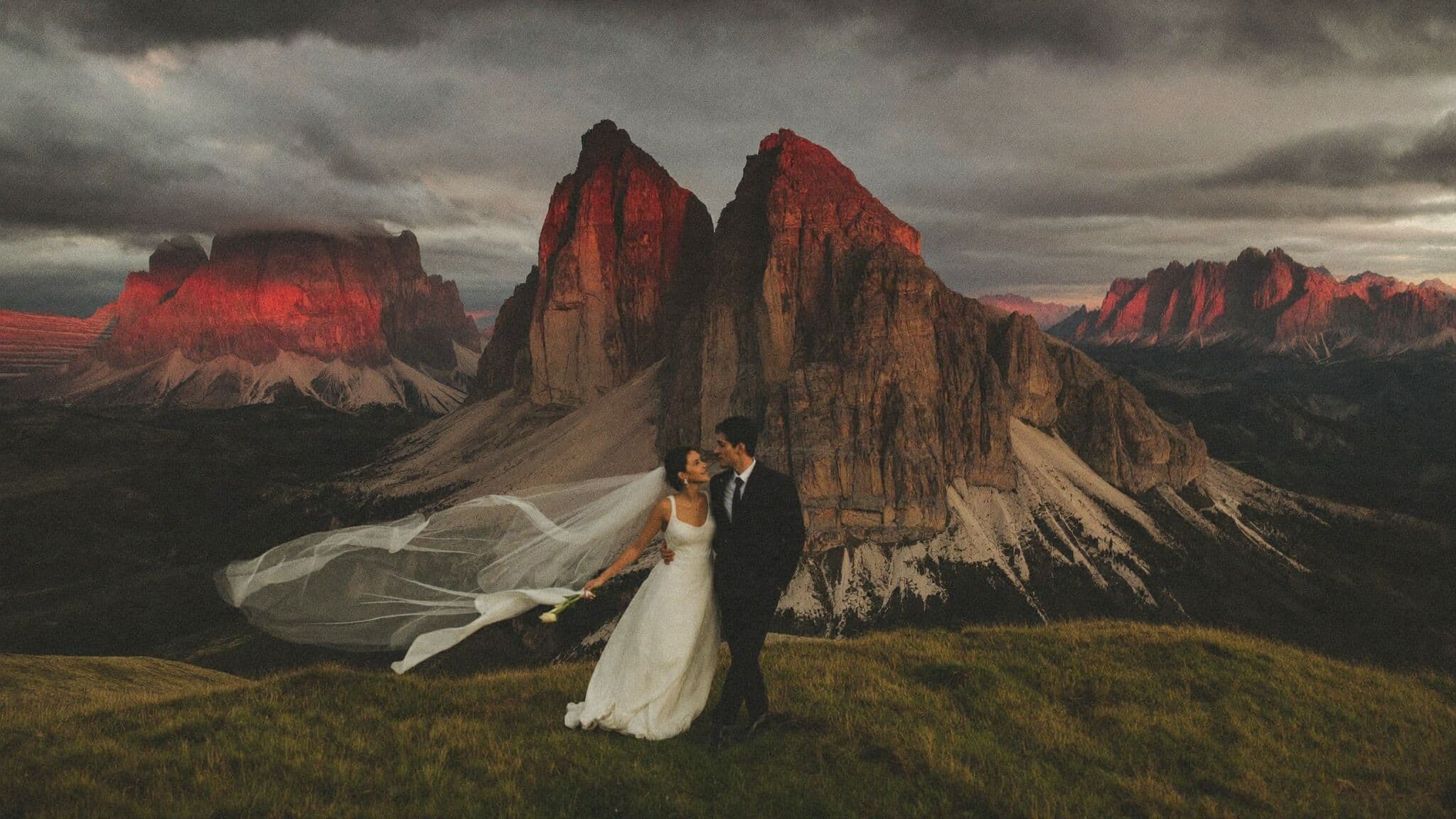 Couple holding hands below the three towers of Tre Cime di Lavaredo during their Dolomites elopement