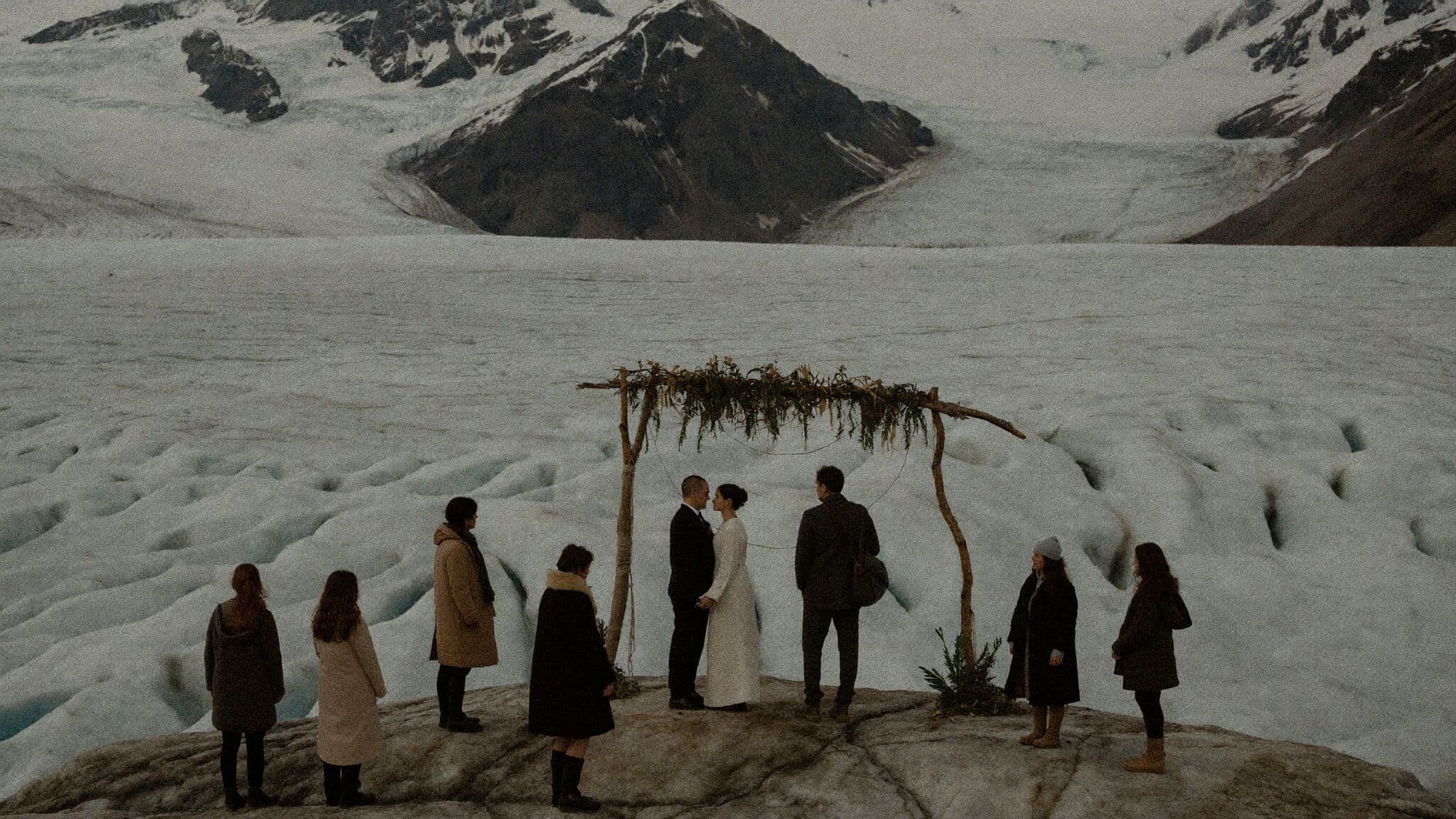 Tiny elopement ceremony with an officiant and four guests on a glacier moraine