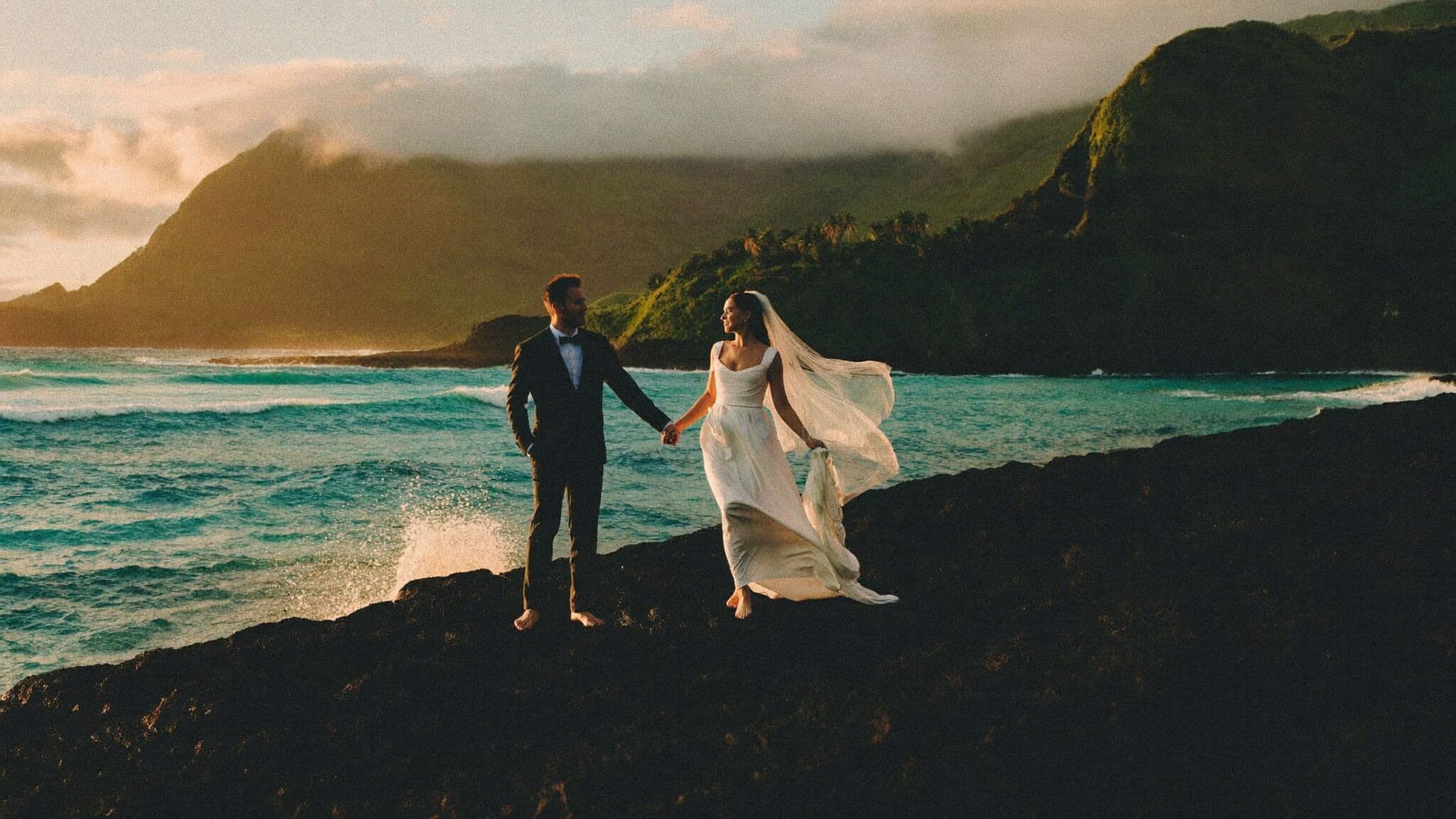 Couple embracing on a lava rock coastline at sunset during their Hawaii elopement on Maui