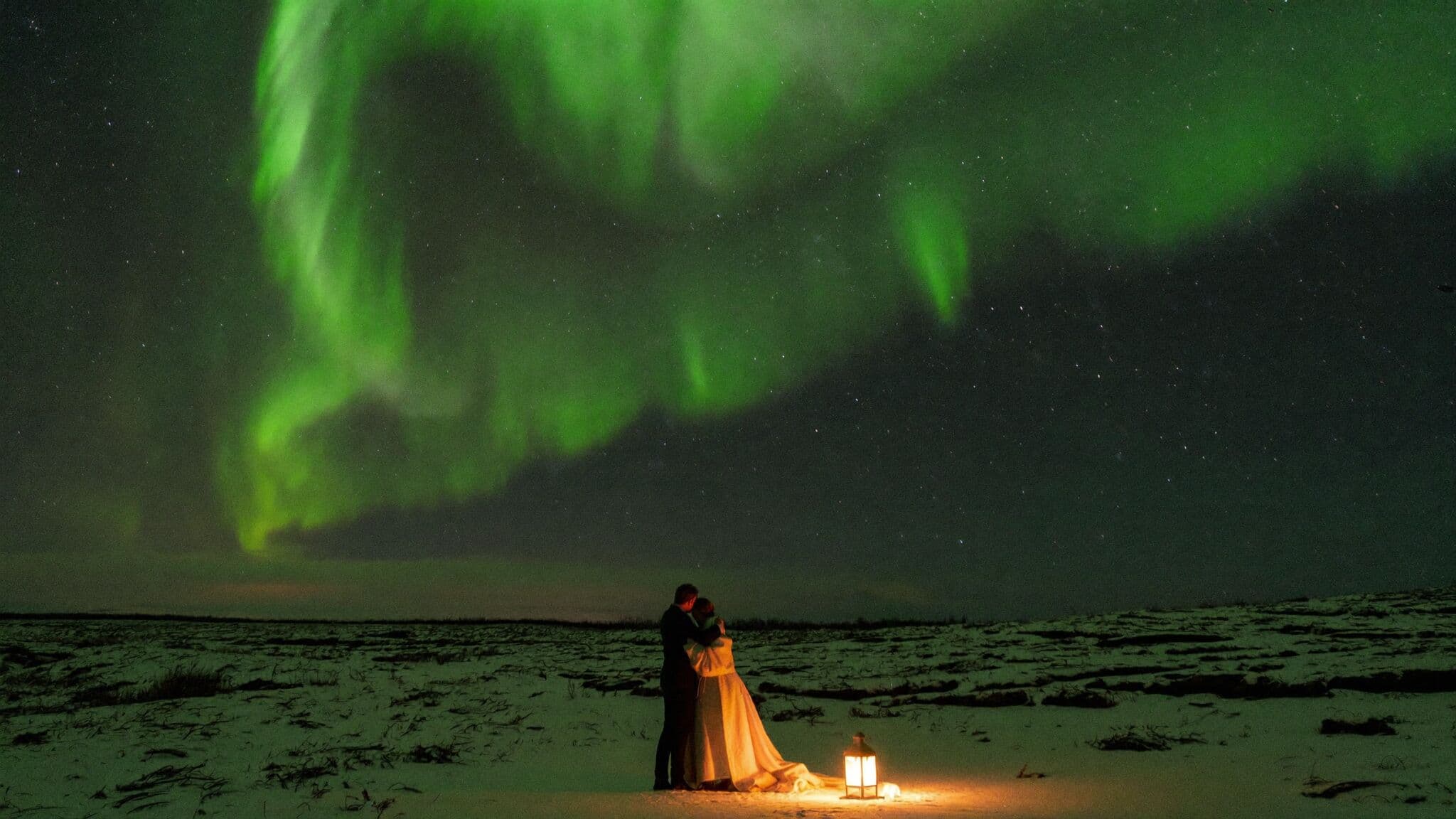 Couple beneath the northern lights during a winter Iceland elopement