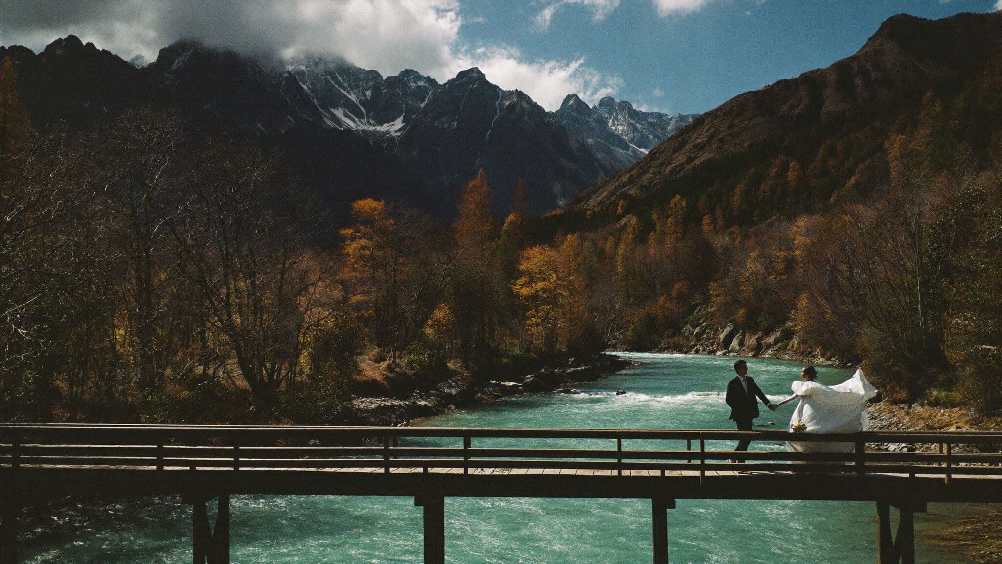 Newlyweds beside the Azusa River in Kamikochi with autumn larches, Japan elopement
