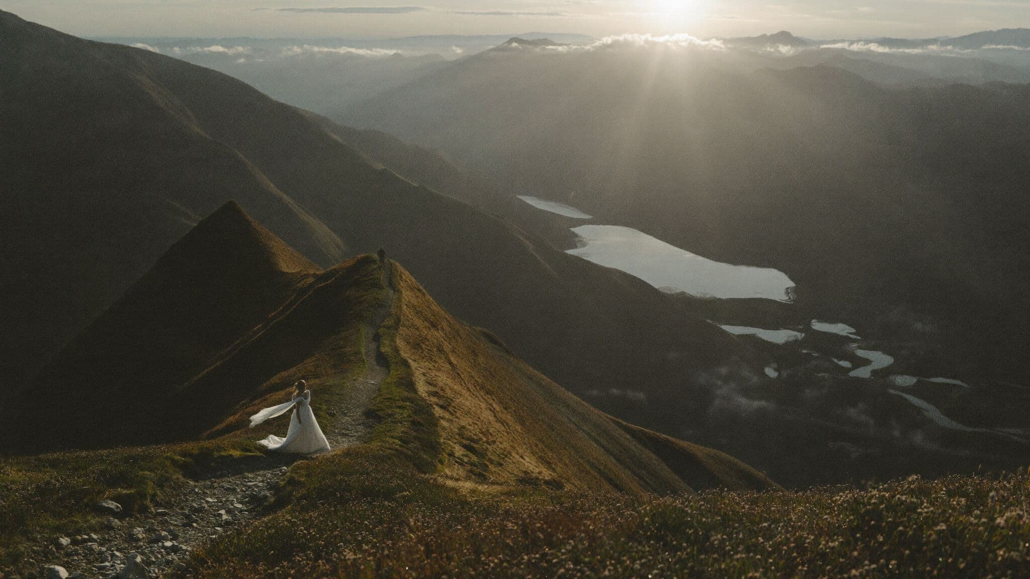 Couple standing on the Roys Peak ridgeline above Lake Wanaka during their New Zealand elopement
