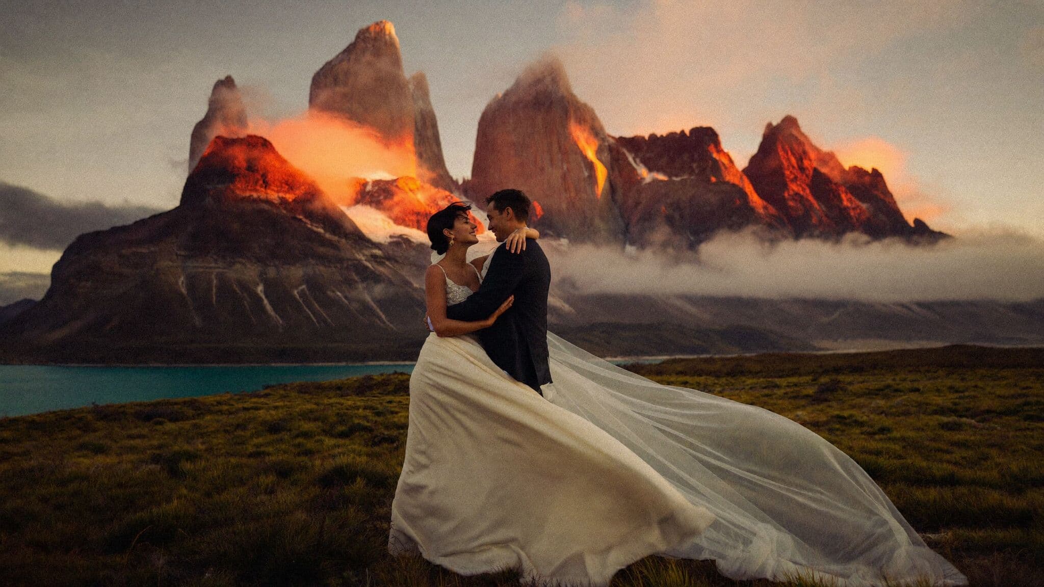 Couple facing the granite towers of Torres del Paine at sunrise during their Patagonia elopement