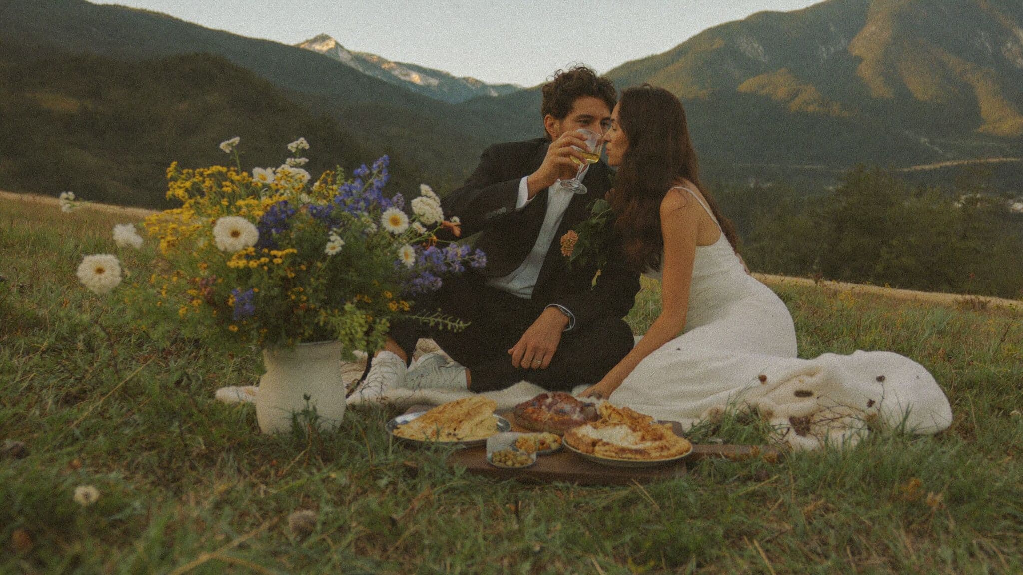 Intimate picnic celebration set up in an alpine meadow after an elopement ceremony