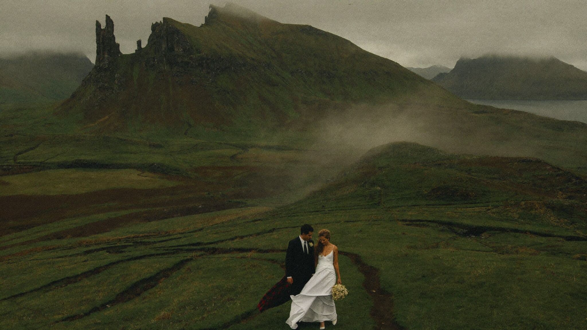 Bride and groom on the winding path through the Quiraing landslip during their Scotland elopement