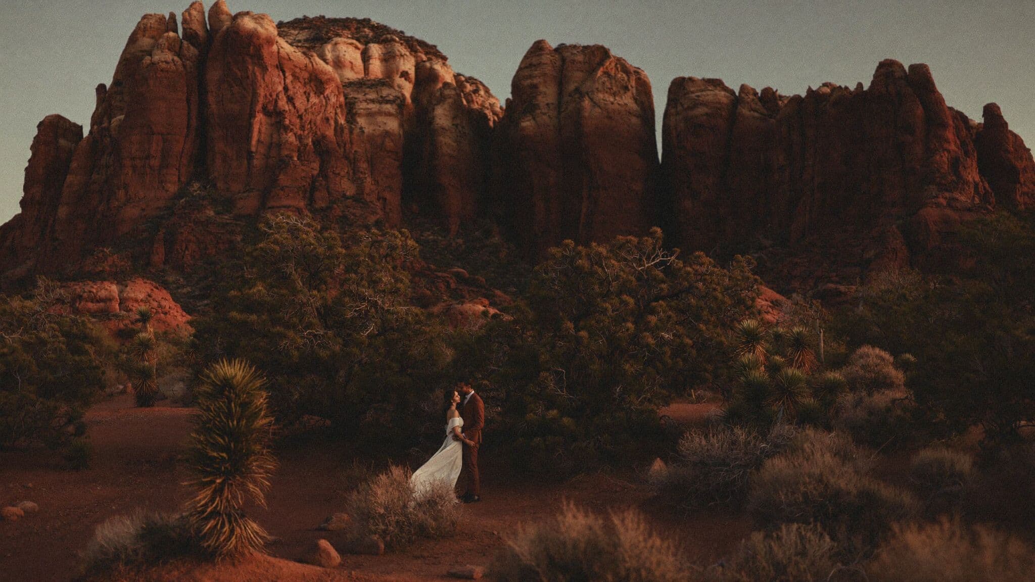 Couple exchanging vows on slickrock facing Cathedral Rock during their Sedona elopement