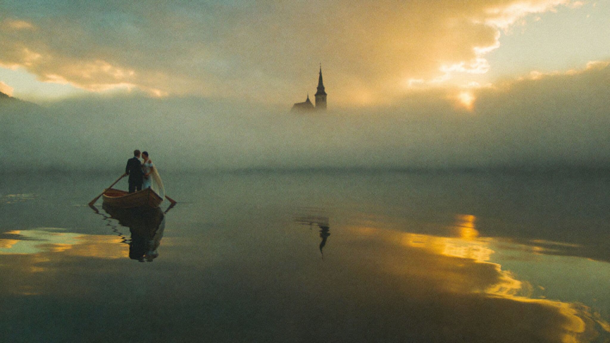 Couple in a wooden pletna boat rowing toward Bled Island church during their Slovenia elopement