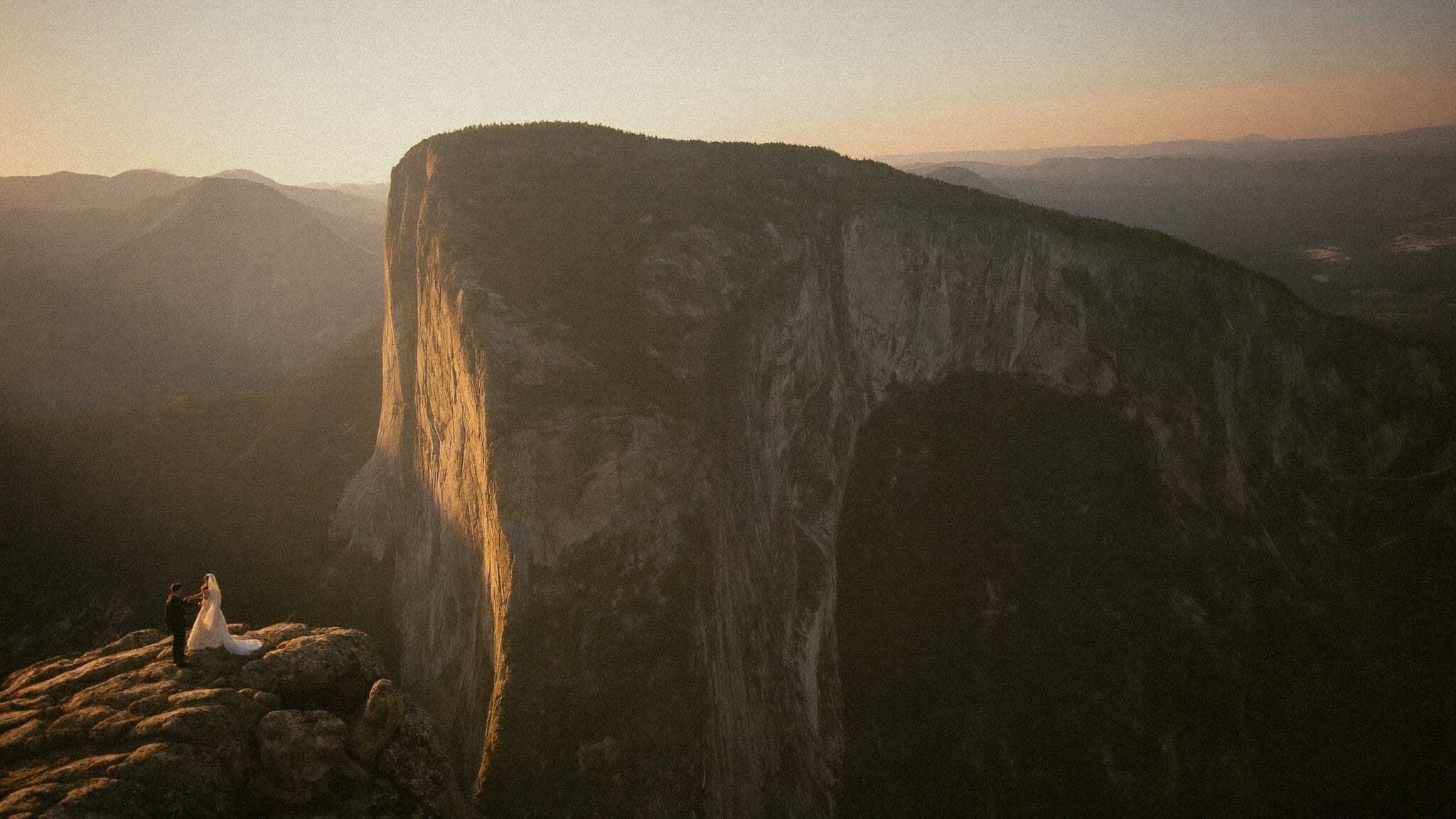Couple standing at the edge of Taft Point above Yosemite Valley during their Yosemite elopement