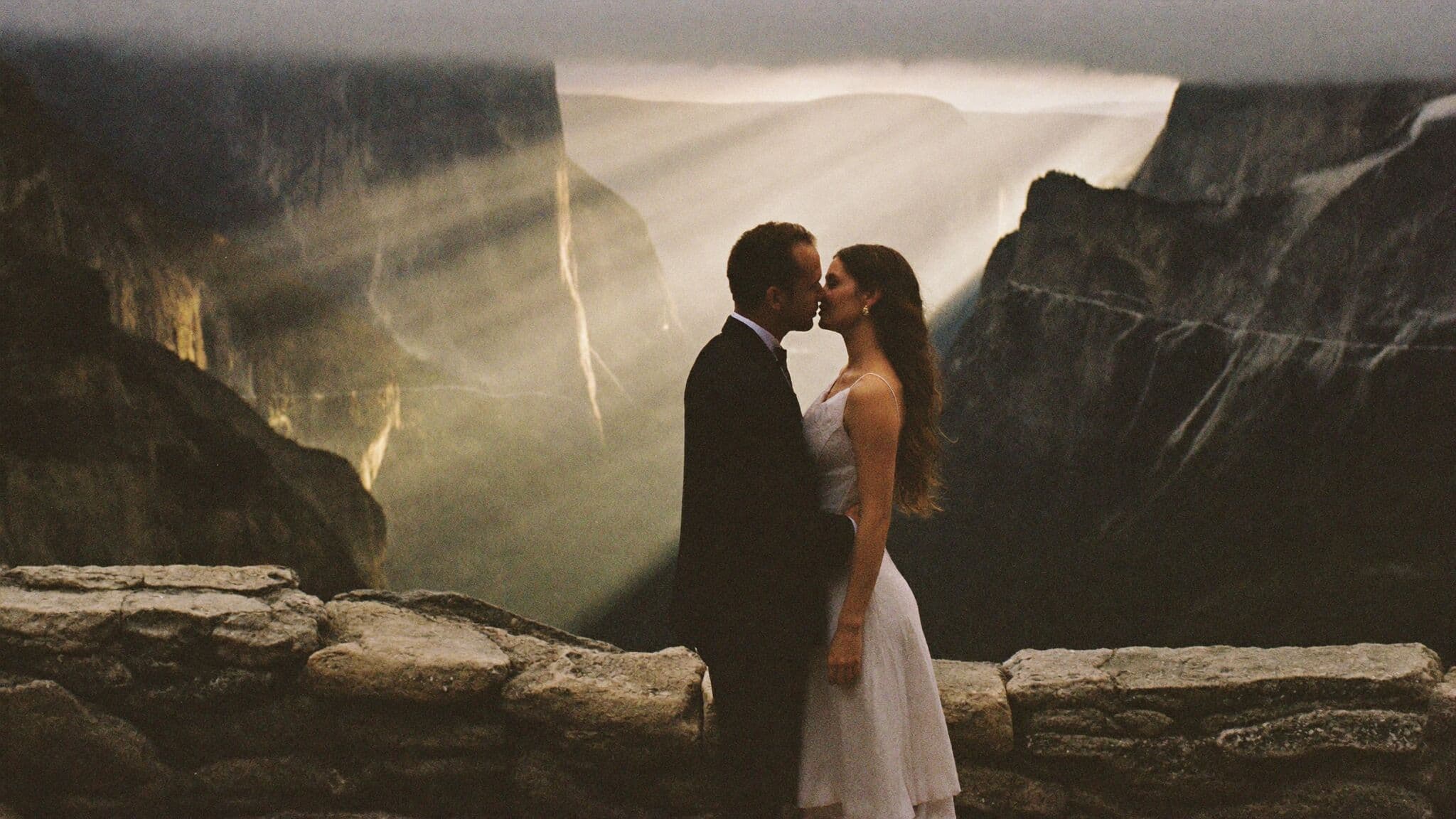 Bride and groom at Tunnel View with El Capitan and Bridalveil Fall behind them, Yosemite elopement